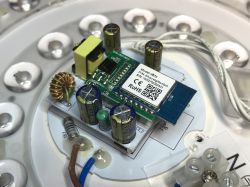 Close-up of the inside of a Woox LED lamp showing the WB3S WiFi module and electronic components.