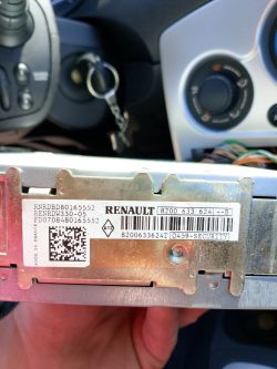 Identification plate of a Renault car radio with visible serial numbers and security code.