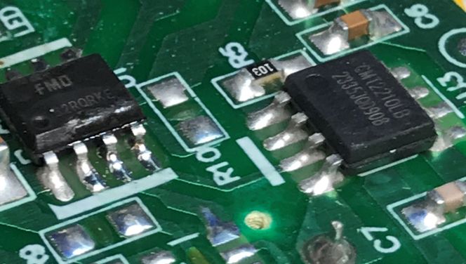 Details of a Printed Circuit Board with Electronic Components Close-up of a printed circuit board with two integrated circuits.