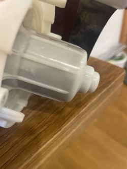 Zbliżenie na część plastikowej pompy myjącej.