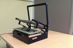 Stół testowy do programowania płytek drukowanych z otwartą pokrywą na biurku.