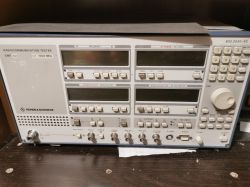 Radiokomunikacyjny tester Rohde &amp; Schwarz CMT 42 na ciemnym blacie z wieloma przyciskami i wyświetlaczami.