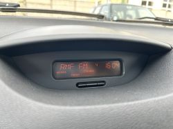 Wyświetlacz radiowy w samochodzie pokazujący stację RMF FM i godzinę 16:04.