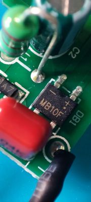 Close-up of an electronic circuit with an MB10F bridge rectifier on a green PCB.