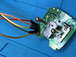 Close-up of circuit board with connected wires and power plug contacts