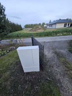 Skrzynka elektryczna przy bramie wjazdowej na działkę, blokująca całkowite otwarcie skrzydła bramy.
