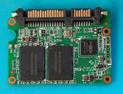 SSD PCB with NAND chips and top edge connectors on a blue background