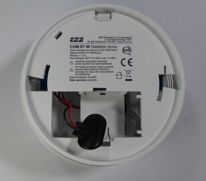 Spód detektora dymu CDM-07W z komorą na baterię 9V i etykietą z danymi technicznymi