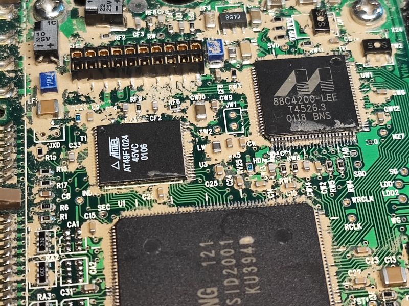 Hard Drive Electronics with Visible Contaminants Close-up of a hard drive PCB with integrated circuits and visible contaminants.
