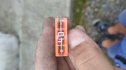 Zbliżenie na przepalony bezpiecznik 40A trzymany w palcach.