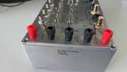 Zbliżenie na przystawkę do pomiaru wzmacniaczy audio z różnymi wejściami i przełącznikami.