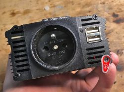 Przedni panel przetwornicy samochodowej z gniazdem elektrycznym i portami USB.