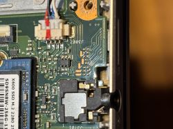 Zbliżenie na płytę główną laptopa ASUS R564U z widocznym gniazdem SSD i złączem przewodów