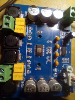 Zdjęcie płytki drukowanej z widocznymi elementami elektronicznymi, takimi jak kondensatory i złącza.