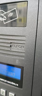 Zbliżenie na domofon marki Elfon z wyświetlaczem i symbolem karty RFID.