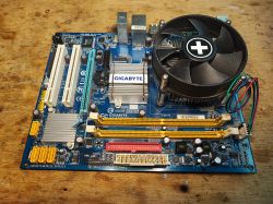 Gigabyte GA-945GCM-S2L Motherboard with Cooling Fan Old computer motherboard with attached CPU cooling fan.