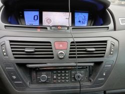 Radio samochodowe w Citroenie C4 Picasso z 2008 roku, pokazujące konsolę z wyświetlaczami.