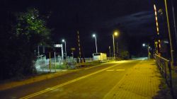 Nocny przejazd kolejowy oświetlony latarniami LED i sodowymi