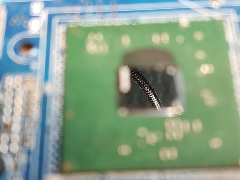 Close-up of a motherboard surface with a camera lens reflection.