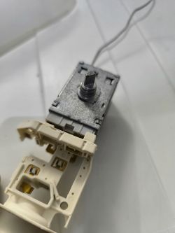 Zdjęcie metalowego elementu elektrycznego z jasną plastikową osłoną.