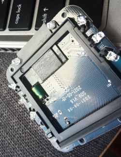 Close-up view of the circuit board of an electronic device with LEDs and ventilation holes.
