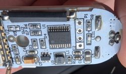 Close-up of a PCB with electronic components, including an integrated circuit, resistors, and capacitors.
