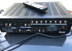 Rear panel of an Oppo AV device with many ports, and a remote control resting on top
