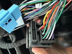 Zbliżenie na wiązkę kabli i złącze ISO radia samochodowego BMW X5 E53.