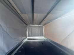 Interior of an empty tarp-covered cargo box with a black floor, view toward the front