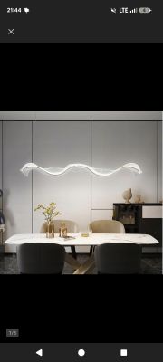 Falista lampa LED zawieszona nad nowoczesnym stołem jadalnianym