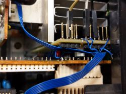 Wnętrze urządzenia elektronicznego z widocznymi przewodami i złączami.