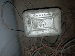 Skrzynka elektryczna z napisem Made in Poland z kilkoma kablami i brakującymi połączeniami