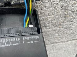 Zbliżenie na złącza wideodomofonu z podłączonymi przewodami COM i NO