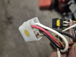 Zbliżenie na białą kostkę elektryczną z podłączonymi kolorowymi przewodami