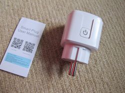 Smart Plug and User Manual White smart plug and user manual on a carpet.