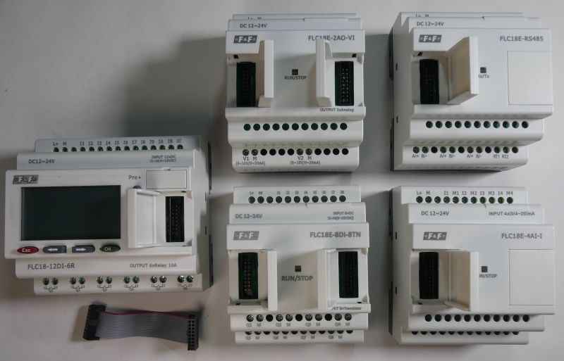 Sterownik programowalny F&amp;F z akcesoriami oraz modułami rozszerzeń widoczny od góry na białym tle.