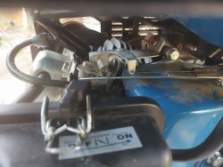 Zbliżenie na mechanizm silnika z widocznymi sprężynami, linkami i przełącznikiem z napisem ON/OFF.