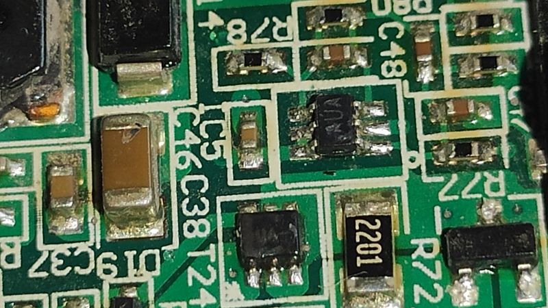 Zbliżenie na płytkę PCB z widocznymi komponentami elektronicznymi, takimi jak rezystory i układ scalony.
