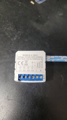 WSM16-4 WiFi switch module on a black table background.
