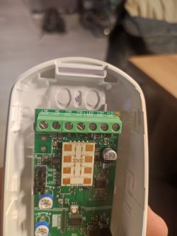 Interior of an alarm device showing connectors and a circuit board.