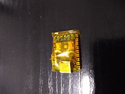 Raspberry Pi RP2040 board wrapped in yellow tape on a black background