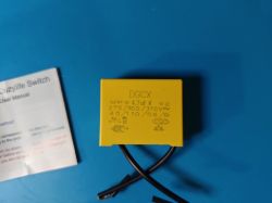 DGCX Capacitor Next to Cozylife Switch Manual Yellow DGCX capacitor next to Cozylife Switch manual on a blue background.