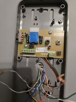 Close-up of a circuit board in a gray enclosure with connected wires.