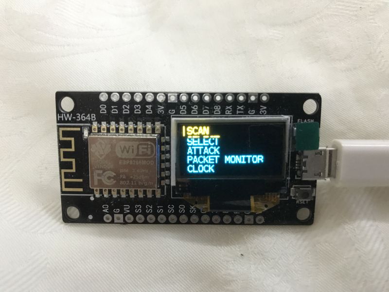 Płytka ESP8266 z małym wyświetlaczem OLED pokazującym menu „SCAN, SELECT, ATTACK, PACKET MONITOR, CLOCK”
