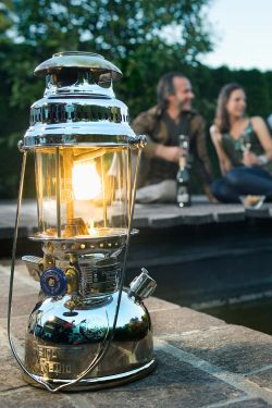Lampa ciśnieniowa na tle pary siedzącej przy stoliku na zewnątrz.