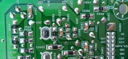 Zbliżenie na tylną część płytki drukowanej PCB z oznaczeniami elementów elektronicznych i punktami lutowania.