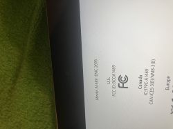 Zbliżenie na ekran urządzenia z informacjami o modelu, numerze EMC i certyfikatami FCC.