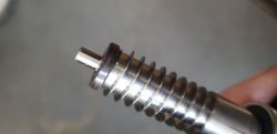Zbliżenie na metalowy wał z magnesem osadzonym na osi spirali.