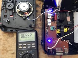Wnętrze radia retro z widoczną elektroniką, głośnikiem i multimetr pokazujący 95,2 mA