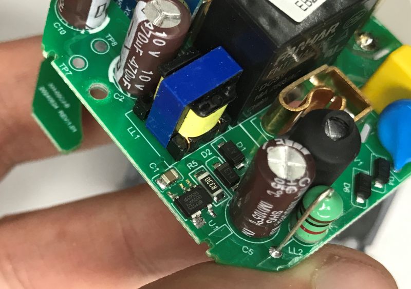 Close-up of a socket’s PCB with relay, capacitors, and SMD components